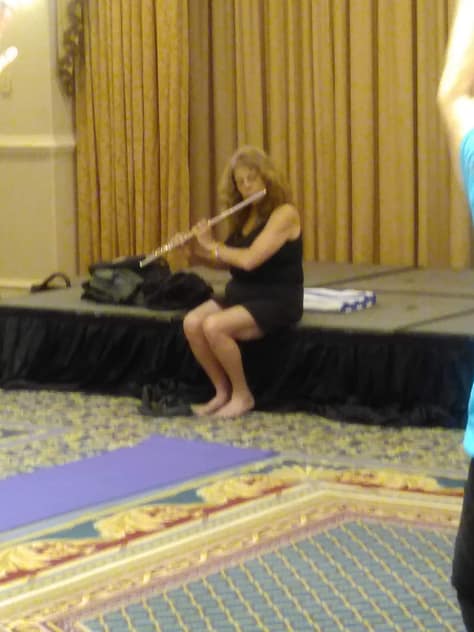 Marla is playing the flute at the Rise And  Shine Yoga with Tinoca at IAFC2019